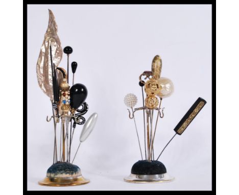 A collection of vintage hat pins contained on two circular based hat pin stands. Includes rhinestone, bead, pearl etc. Please