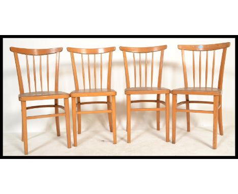 A set of four vintage retro 20th century wooden dining kitchen utility chairs raised on tapered supports with rail backs.