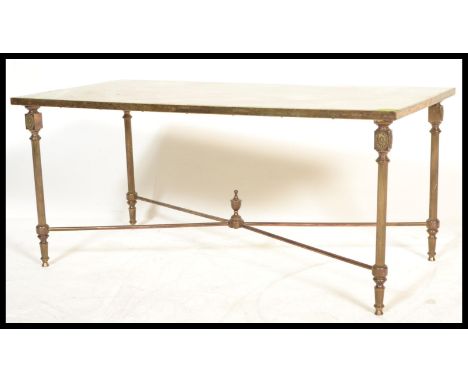 A vintage 20th century gilt brass coffee table having an onyx top raised on column supports with cross stretcher. Measures 41