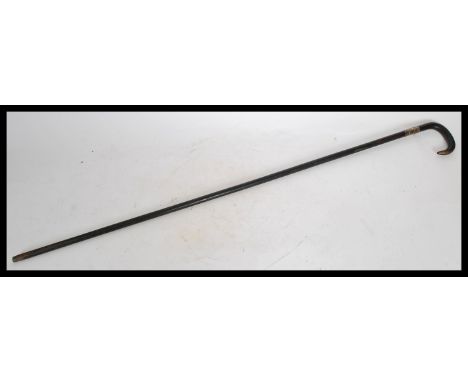 A 19th century Victorian silver collared walking stick cane having a tapering ebonised shaft with shaped horn handle.