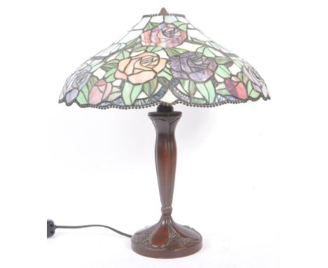 A 20th Century Tiffany style table lamp light with dual lamp bulb sockets having pink and purple stained glass rose design to