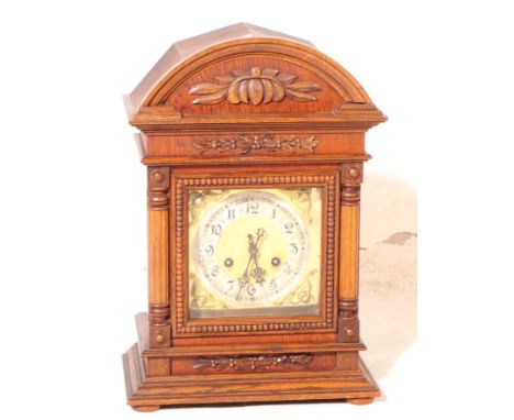 An early 20th century circa 1930s English oak cased mantle clock, with German movement. The clock having a gilt face with ara