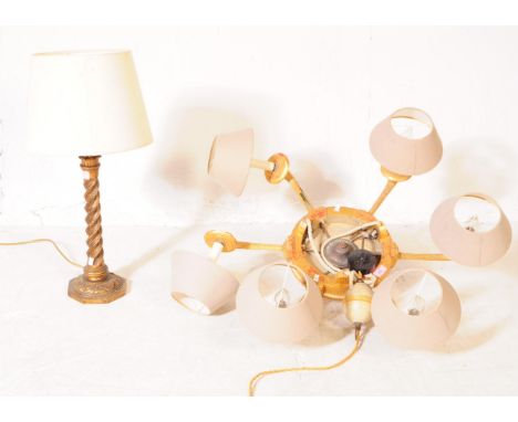 A 20th century French Louis XVI revival six arm chandelier alongside a gesso side table lamp. The chandelier having six flute
