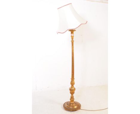 A 20th Century painted gilt wood floor standing standard lamp with lamp shade. The central column turned having foliate leaf 