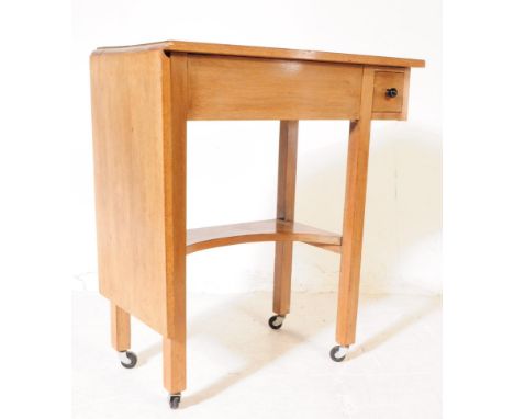 A vintage 20th century oak sewing / side table. With small needle / thread drawer, with gate leg extending table, curved cent