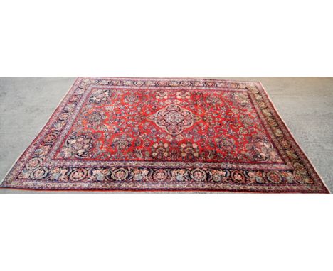 A 20th century wool Persian style carpet with central blue, brown and red medallion. 258cm x 360cm