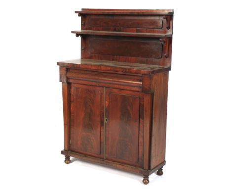 A Victorian mahogany chiffonier. With two shelves on scrolled brackets, above two panelled doors enclosing a shelf, raised on