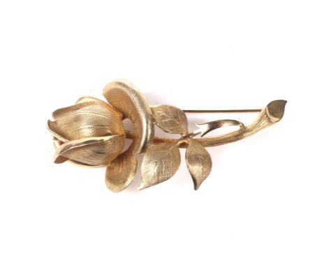 A vintage 9ct gold flower brooch. In the form of a stylised rose(?) stem with a textured and polished finish, import hallmark