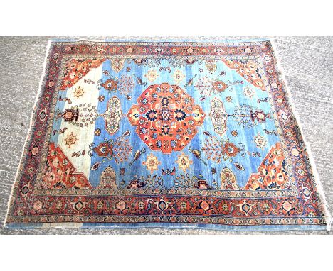 A 20th century Tabriz Persian carpet. Decorated with floral medallions and scrolls, on a blue ground, measuring approximately