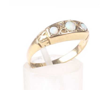 An early 20th century 18ct gold and opal three stone gypsy-type ring. The slightly graduated round cabochon white opals each 