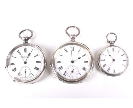 Two open faced silver pocket watches and a smaller fob watch. One with British hallmarks, another stamped 935 and the fob wat