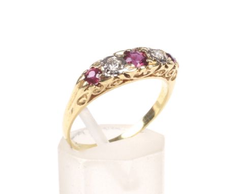 A vintage ruby and diamond five stone carved half-hoop ring, the three graduated round mixed-cut rubies spaced by small round