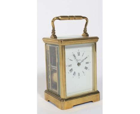 A French brass carriage clock. The white enamelled dial named for Angelus, with black Roman numerals, within bevelled glass p