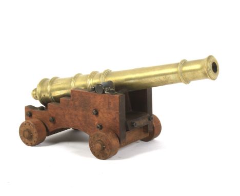 An artillery brass mounted desk top cannon on a wooden carriage. With stud work wheels, 29cm long Condition Report: Interior 
