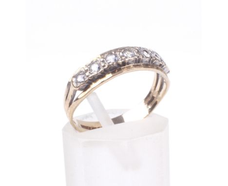 A vintage 9ct gold and cubic zirconia seven stone half-eternity ring. The round mixed-cut stones approx. 2.5mm diameter grain