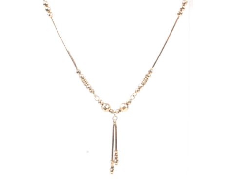 A Continental yellow metal necklace. The front designed as a row of graduated multi-shaped and facetted beads suspending a pa