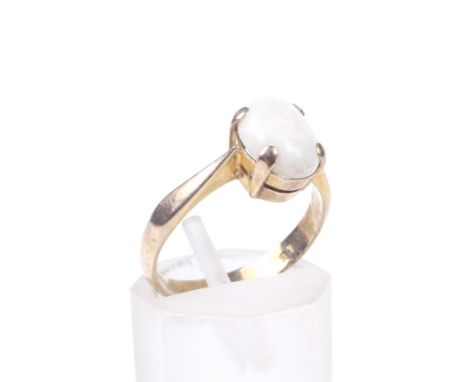 A vintage opal single stone ring. the oval cabochon white opal displays a muted play of colours and is claw set in yellow bet
