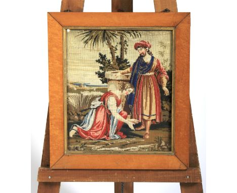 A maple framed needle work tapestry. Depicting a Mediterranean scene a lady kneeling in front of a robed man, 43cm x 48cm