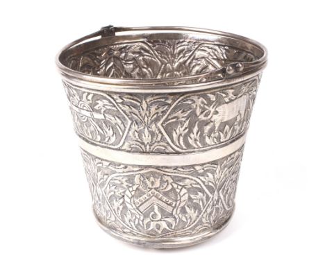 An Indian white metal small ice bucket. With double swing handle, cast with animals, a bow and arrow and other devices amongs
