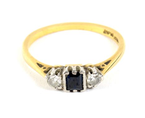 An 18ct gold and platinum set three stone sapphire and diamond ring. The central sapphire flanked by two diamonds (2.1 grams 