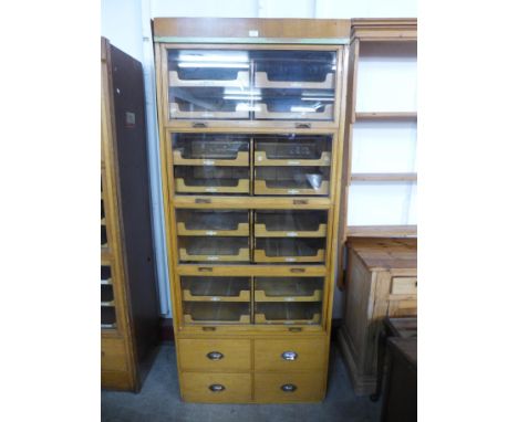 A mid 20th Century oak haberdashery shop cabinet 