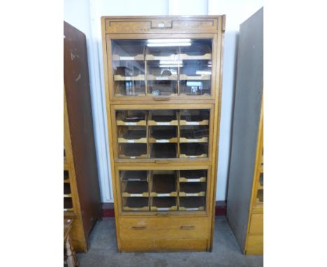 A mid 20th Century oak haberdashery shop cabinet 