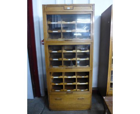 A mid 20th Century oak haberdashery shop cabinet 