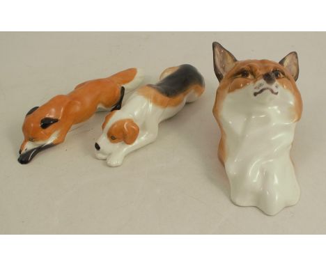 A Royal Worcester model, of a recumbent fox, shape number 3570, and a hound, shape number 3571, together with a fox wall mask