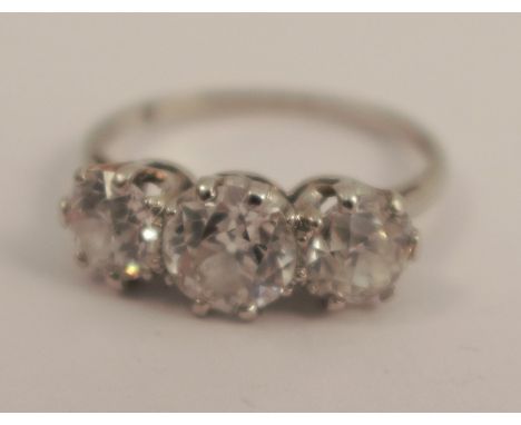 A three stone diamond ring, the white mount unmarked, the graduated old brilliant cuts totalling approximately 1.7 cts, finge