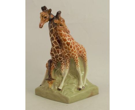A Royal Worcester model, of two giraffes with a calf, on a triangular shaped green base, impressed and inscribed giraffes mod