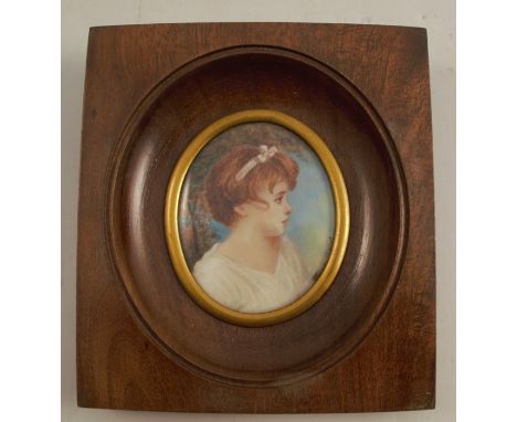 A 20th century portrait miniature, of a girl in profile, signed, maximum diameter 2.5ins