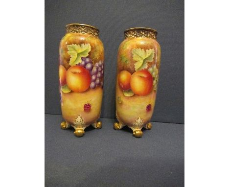 A pair of Royal Worcester cylindrical shaped spilll vases, decorated all around in hand painted fruit by Leaman, with pierced