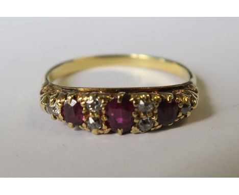 An early 20th century ruby and diamond ring, unmarked, the three oval cuts with pairs of diamonds between and one to either e