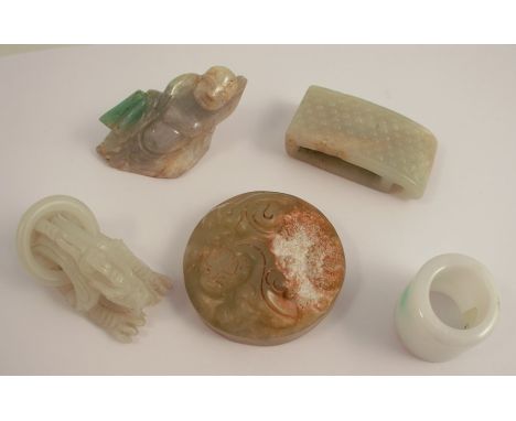 Five Chinese and oriental carved items of jade and hardstone, comprising a belt hook, a figure of a crouching tiger, a recumb
