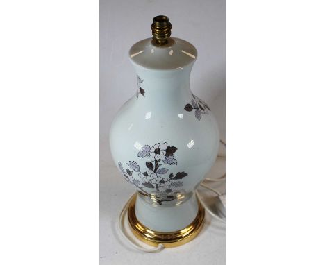 A French porcelain table lamp of baluster form on a cream ground, decorated with flowers