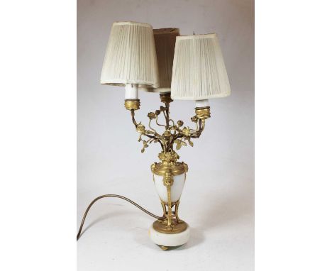 A late 19th / early 20th century alabaster and gilt metal mounted three branch table lamp, the three arms having foliate deco