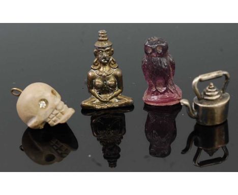 A miniature carved amethyst owl, 25mm; together with a carved composition skull pendant; a miniature Buddha; and a white meta