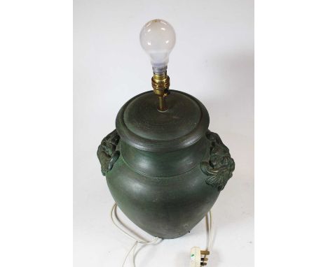 A modern green glazed table lamp of squat baluster form having green man mask handles with silk shade, height 36cm