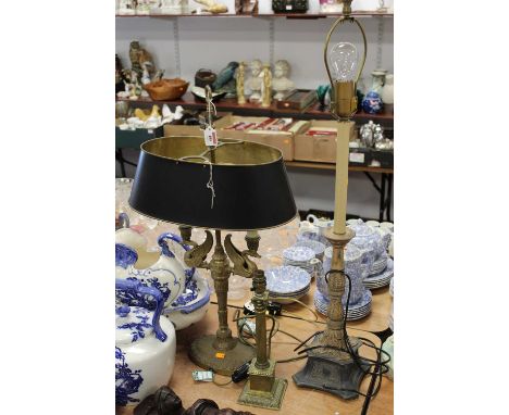 A 20th century table lamp in the Egyptian style, the twin sconces in the form of swans, having a Toleware type shade, h.73cm;