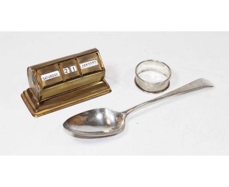 An Art Deco brass cased perpetual desk calendar; together with a George III silver serving spoon; and a silver napkin ring (3