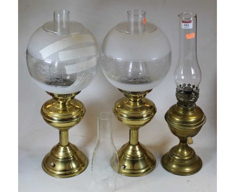 An early 20th century brass pedestal oil lamp, having an etched opalescent shade; together with two other brass pedestal oil 
