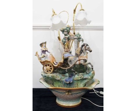 A large Lladro(?) porcelain model of a lady in a horse-drawn carriage, on a naturalistic base on a further stand with twin li
