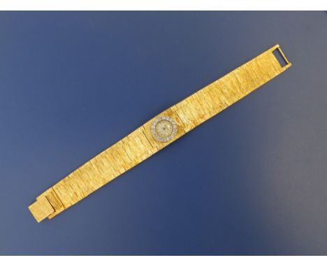 A boxed lady's 18ct gold diamond set Jaeger LeCoultre bracelet wrist watch, the small circular white dial with diamond bezel,