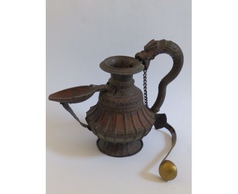 An antique copper & brass Nepalese Sukunda prayer lamp, the handle terminating in a dragon's head, having a ladle attached to