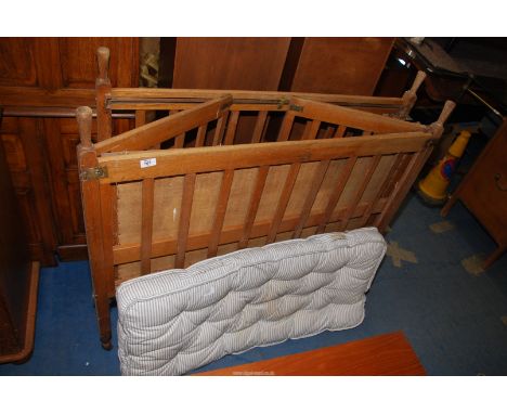 An old pine folding cot bed on castors with mattress.