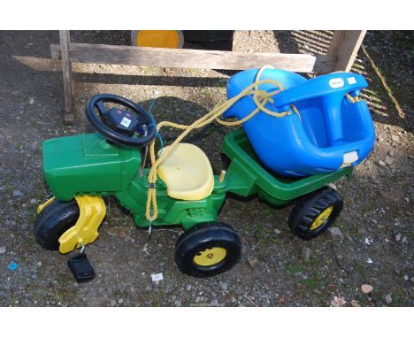 A Child's ride along tractor and trailer and a Little Tike's swing.