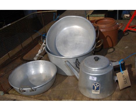 A stainless steel catering kettle and three pans.