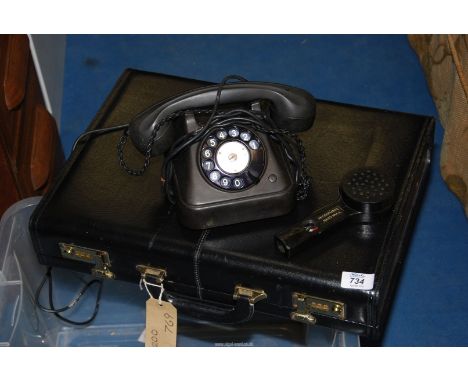 A Bakelite telephone and a briefcase.