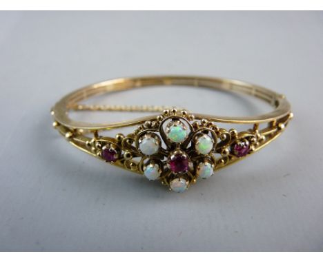 A NINE CARAT GOLD OPAL AND RUBY BRACELET, the bracelet of triple split form with a fine floral display of centre ruby with si