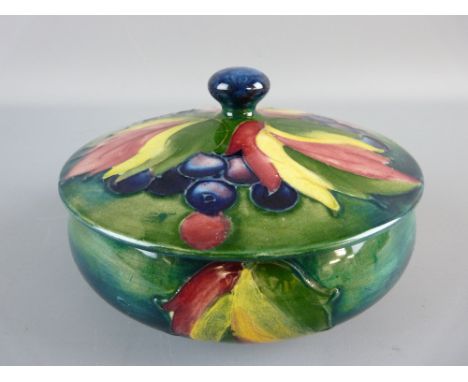 A MOORCROFT LEAF AND BERRY POWDER BOWL AND COVER, 15 cms diameter, on a tonal green/blue ground, impressed to the base 'Moorc